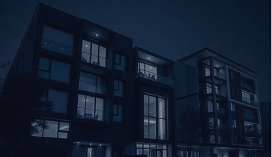 Contemporary apartment building at night with lit windows